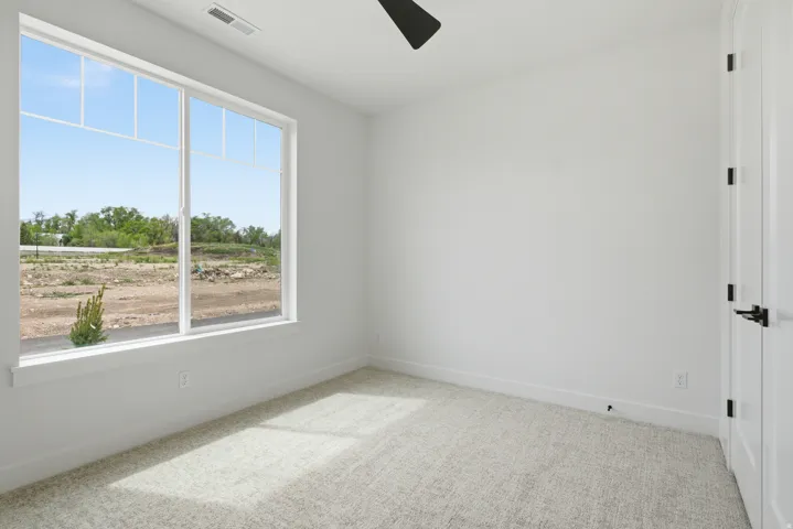 Unfurnished room featuring light colored carpet and ceiling fan