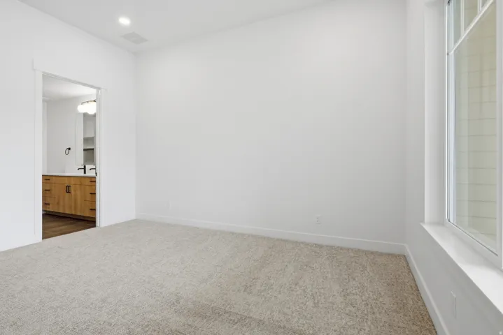 Unfurnished bedroom featuring carpet flooring, ensuite bath, and recessed lighting