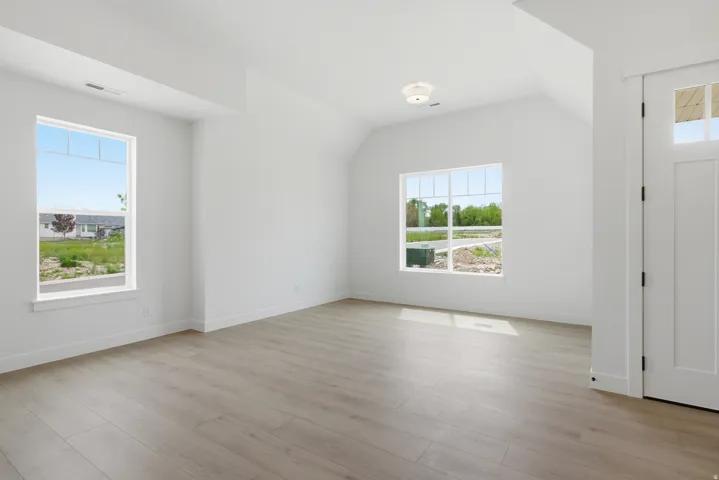 Entryway with vaulted ceiling and light wood-type flooring