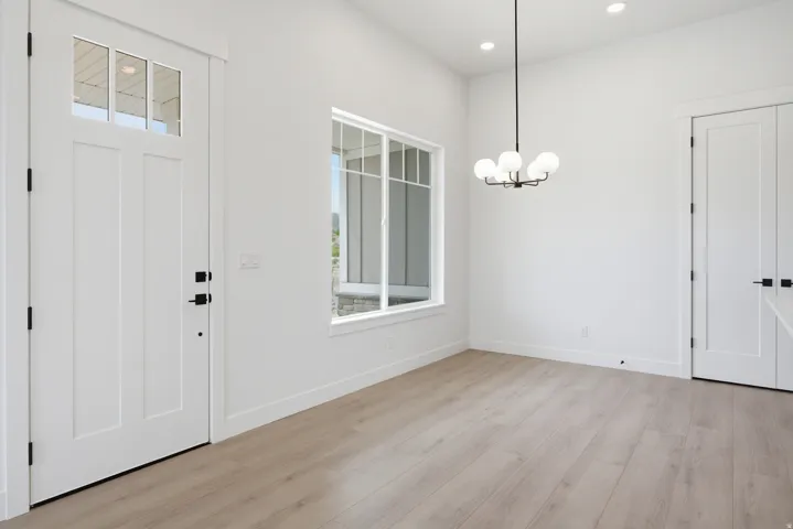 Foyer with light wood-type flooring and hanging lights