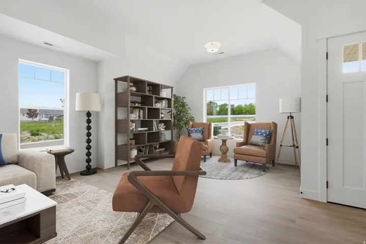 Sitting room with light wood finished floors and lofted ceiling