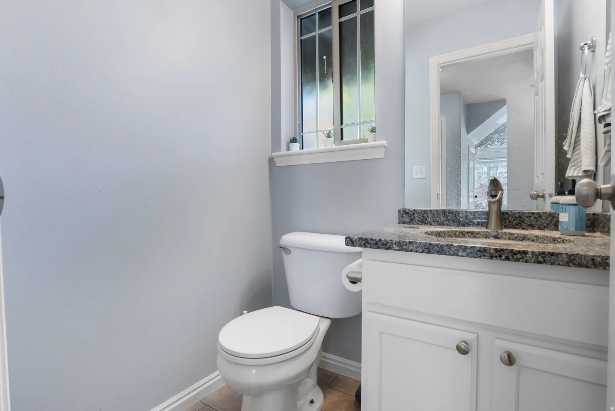Half Bathroom featuring vanity and light tile patterned flooring