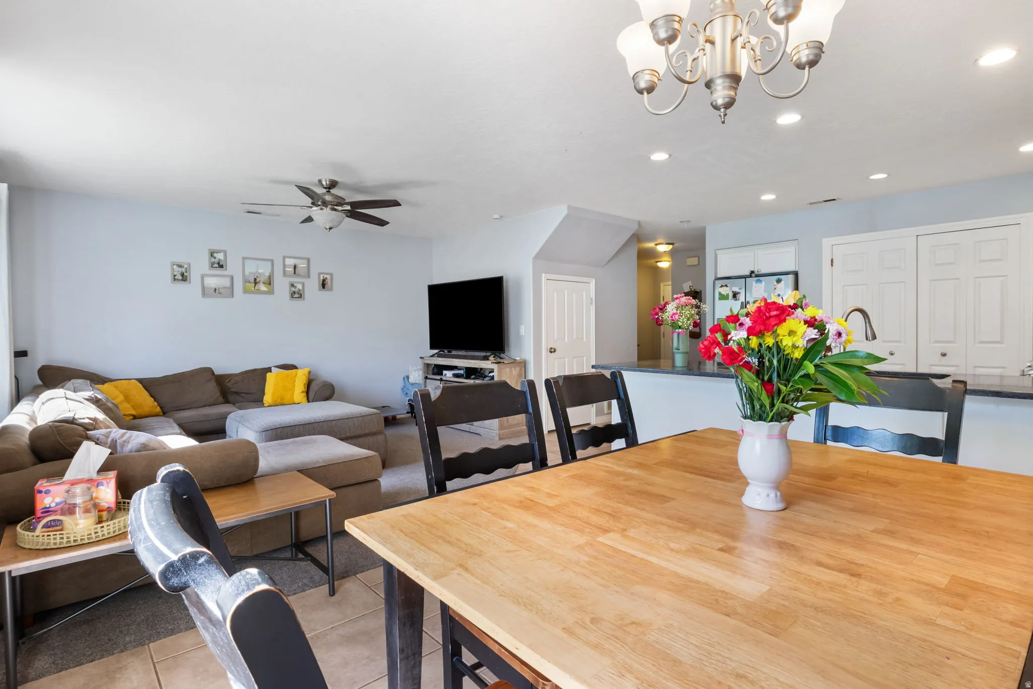 Dining space featuring light tile patterned flooring, ceiling fan, and hanging lights