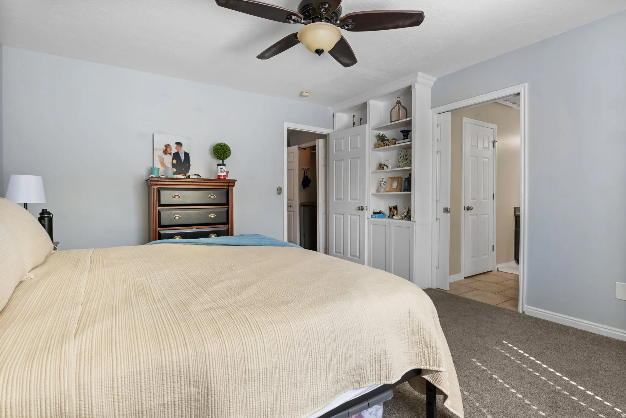 Bedroom with a ceiling fan and light colored carpet