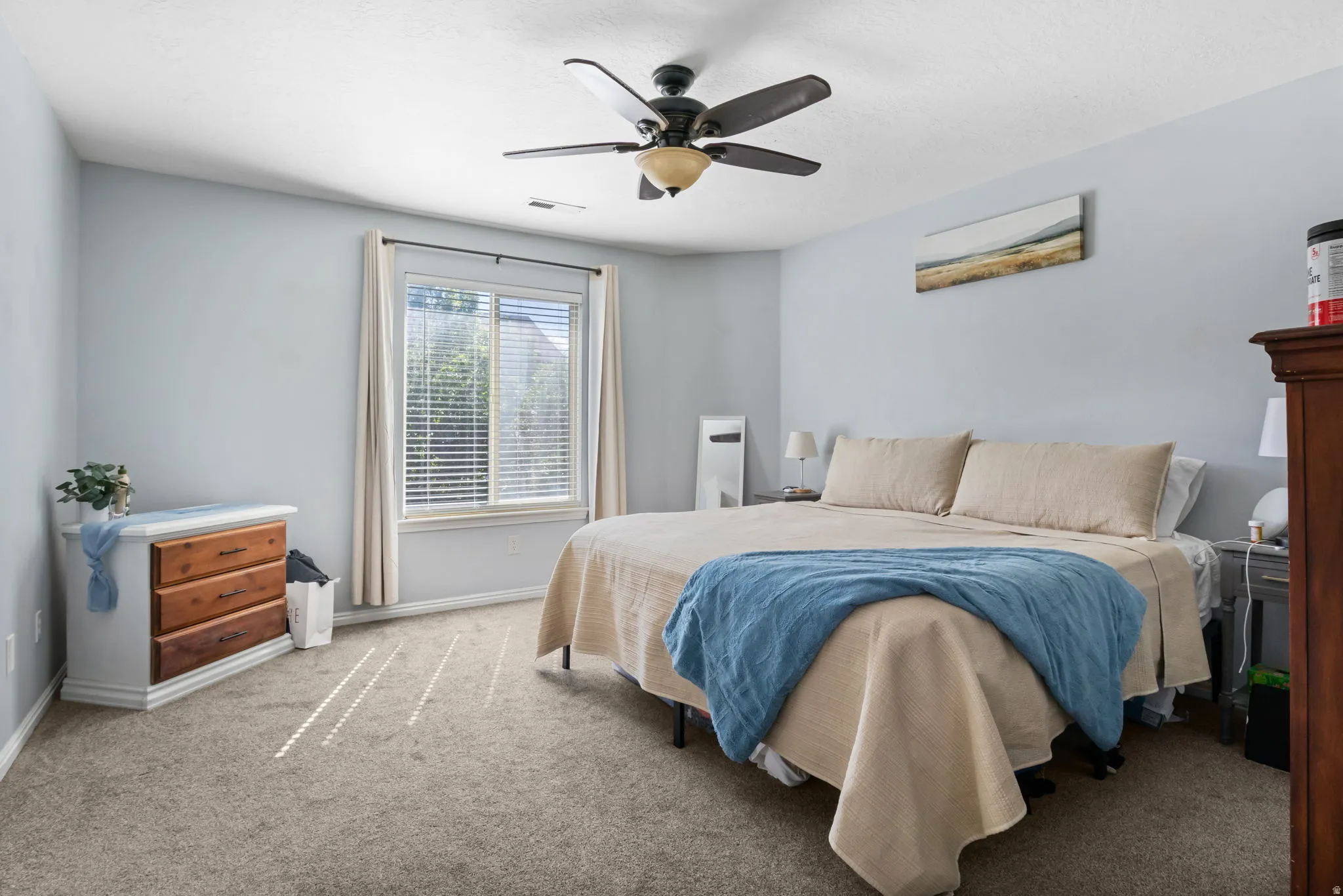 Carpeted bedroom with ceiling fan and baseboards