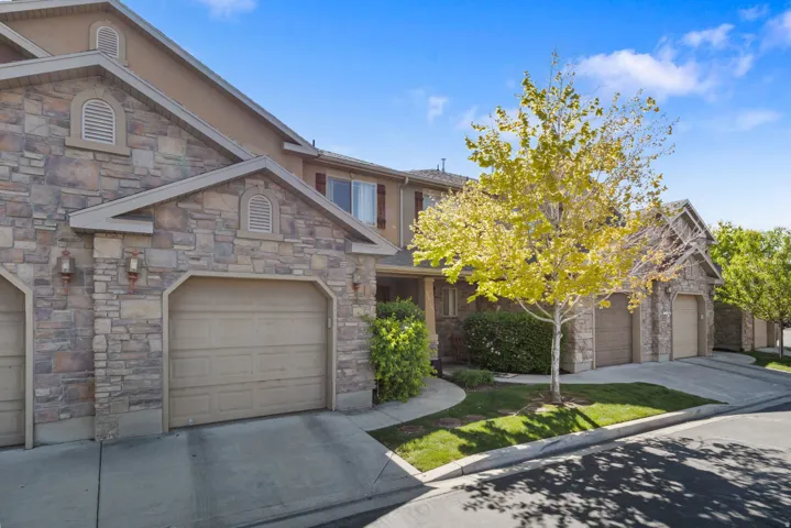 Craftsman inspired home featuring stone siding, a garage, and concrete driveway