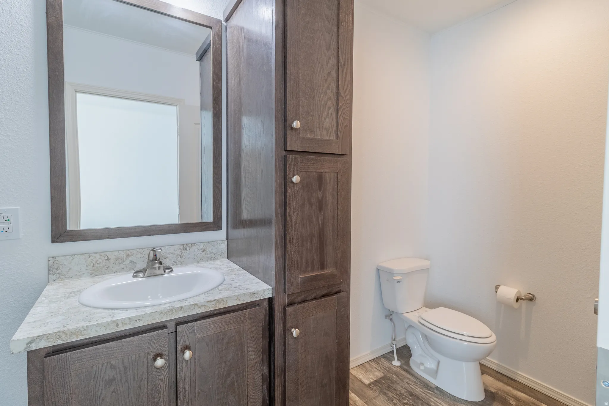 Half bath with vanity and wood finished floors