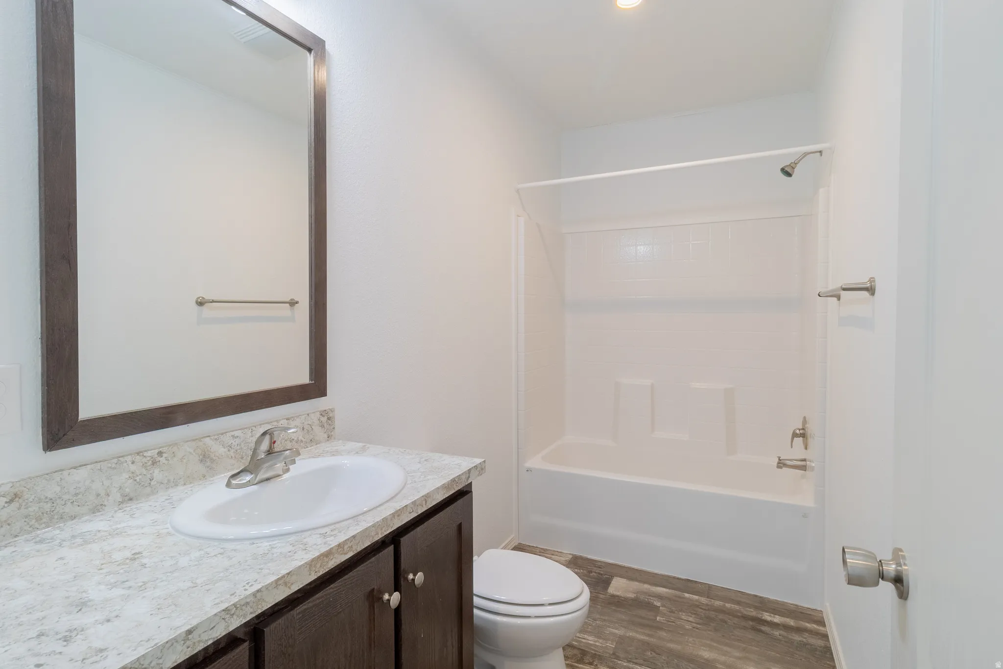 Full bath featuring vanity, dark wood-style floors, and tub / shower combination
