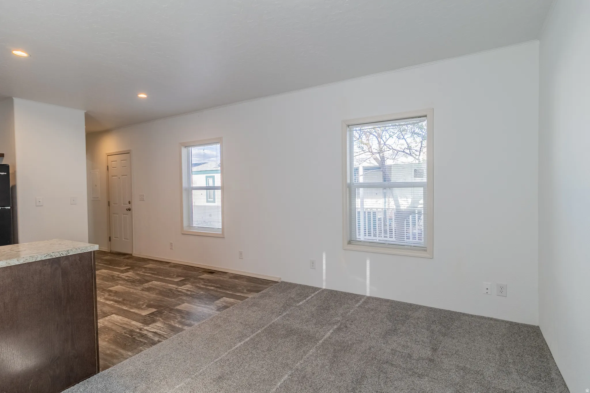 Unfurnished living room featuring dark wood-style floors