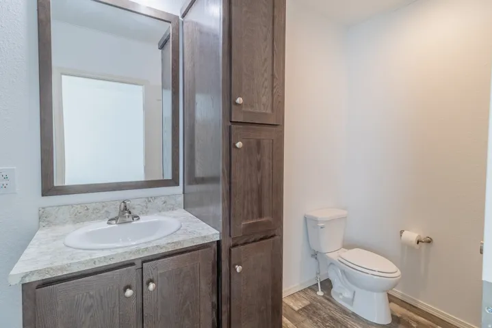 Half bath with vanity and wood finished floors