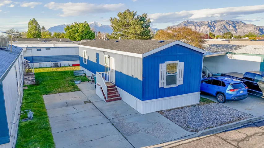 Manufactured / mobile home featuring a mountain view and a front yard