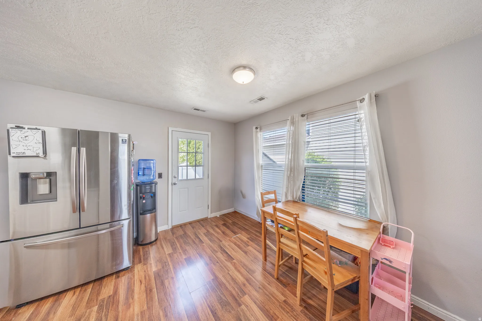 Dining area featuring light wood-style floors and a textured ceiling