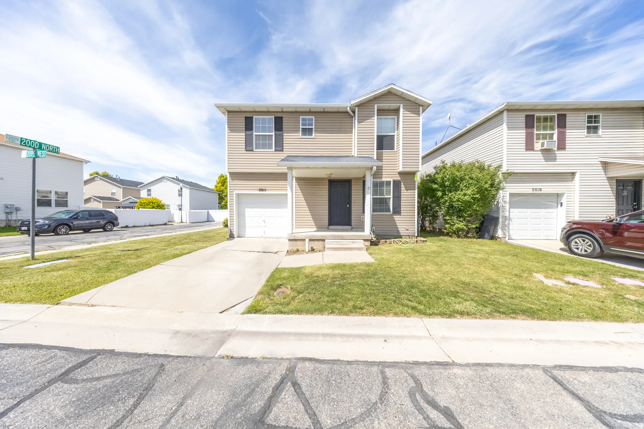 Traditional-style home with an attached garage, a front lawn, and driveway