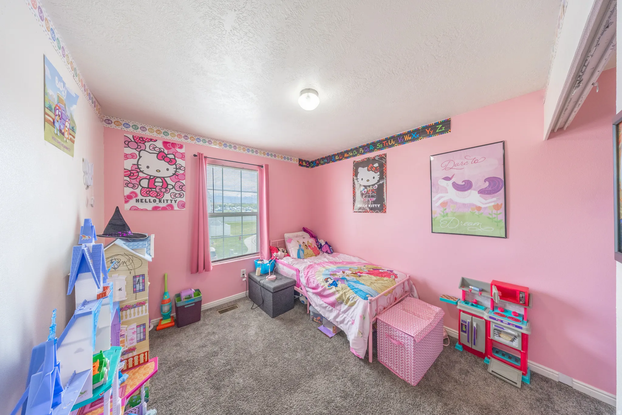 Bedroom featuring dark carpet and a textured ceiling