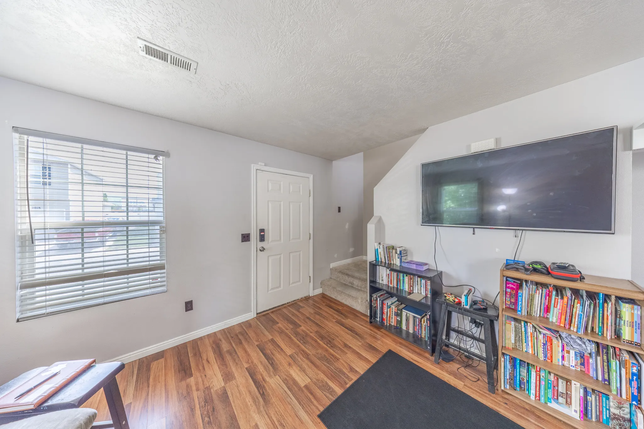Foyer entrance with wood finished floors and a textured ceiling