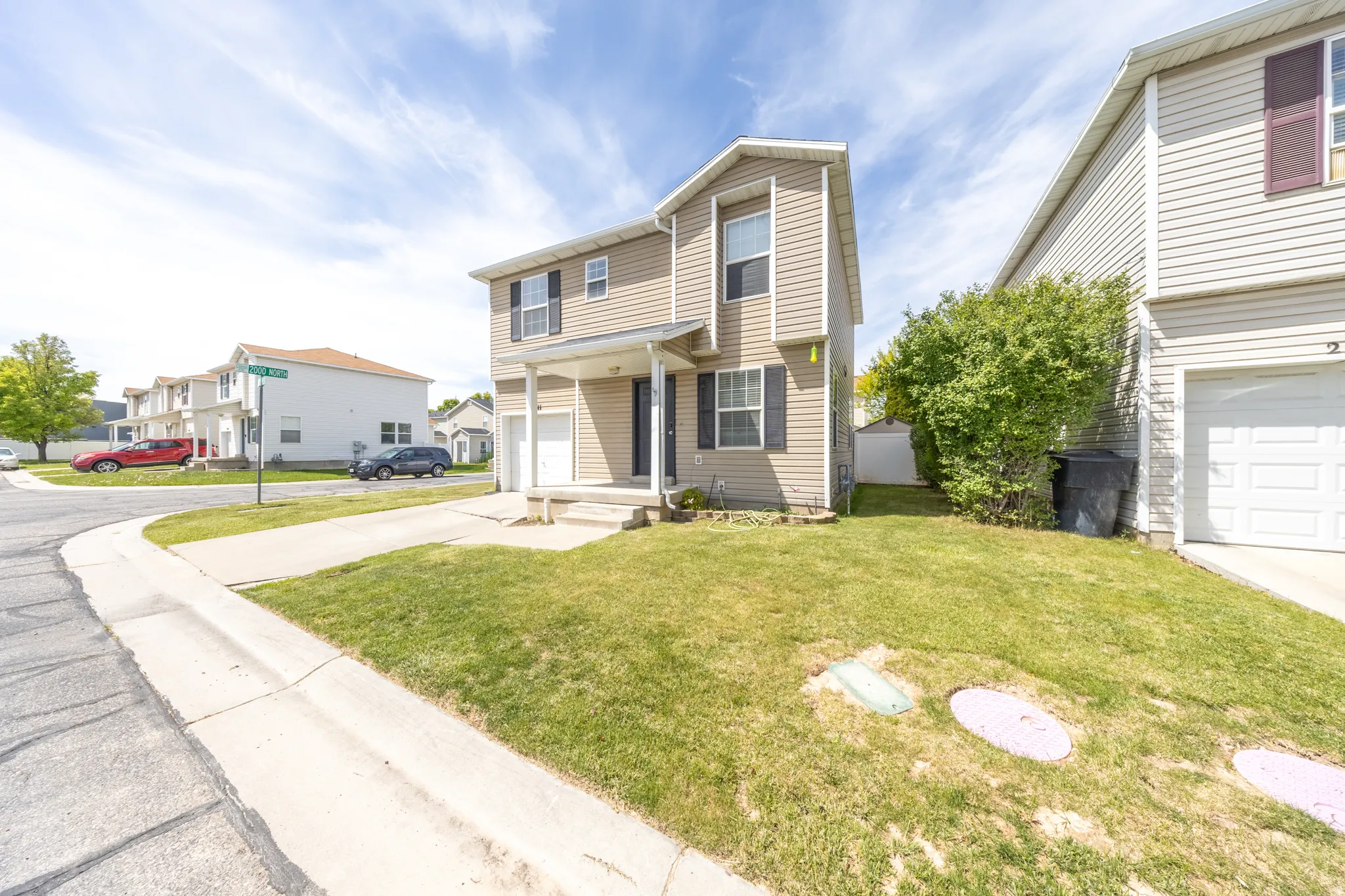 Traditional home featuring a residential view, a front lawn, and an attached garage