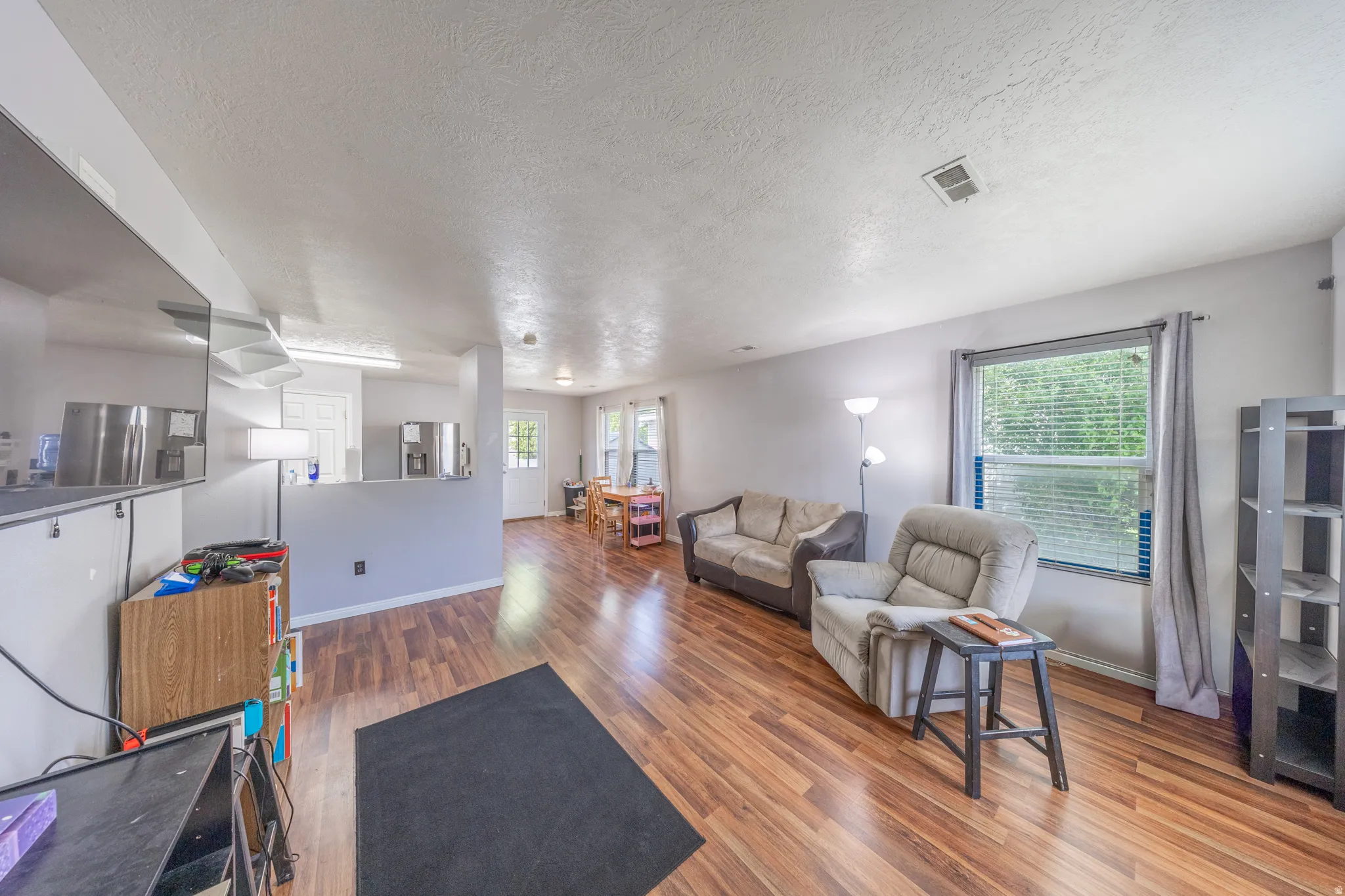 Living area with wood finished floors and a textured ceiling
