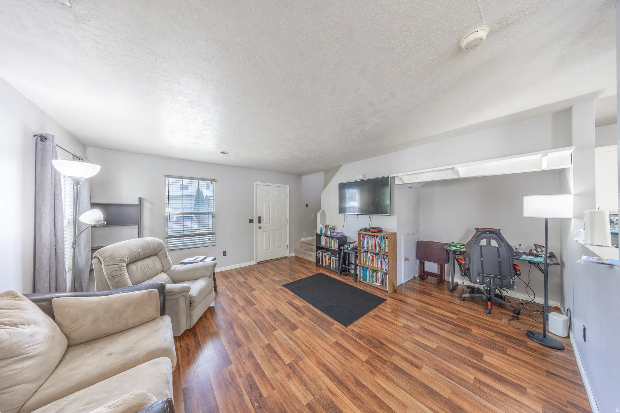 Living area featuring wood finished floors and a textured ceiling