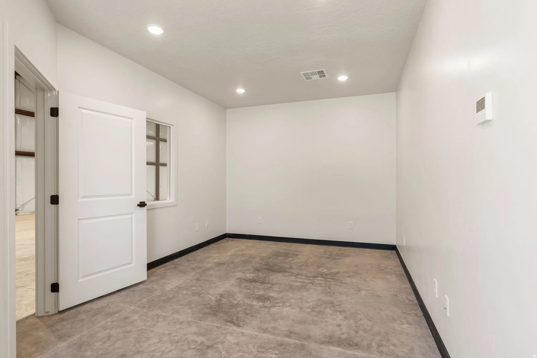 Spare room featuring concrete floors and recessed lighting