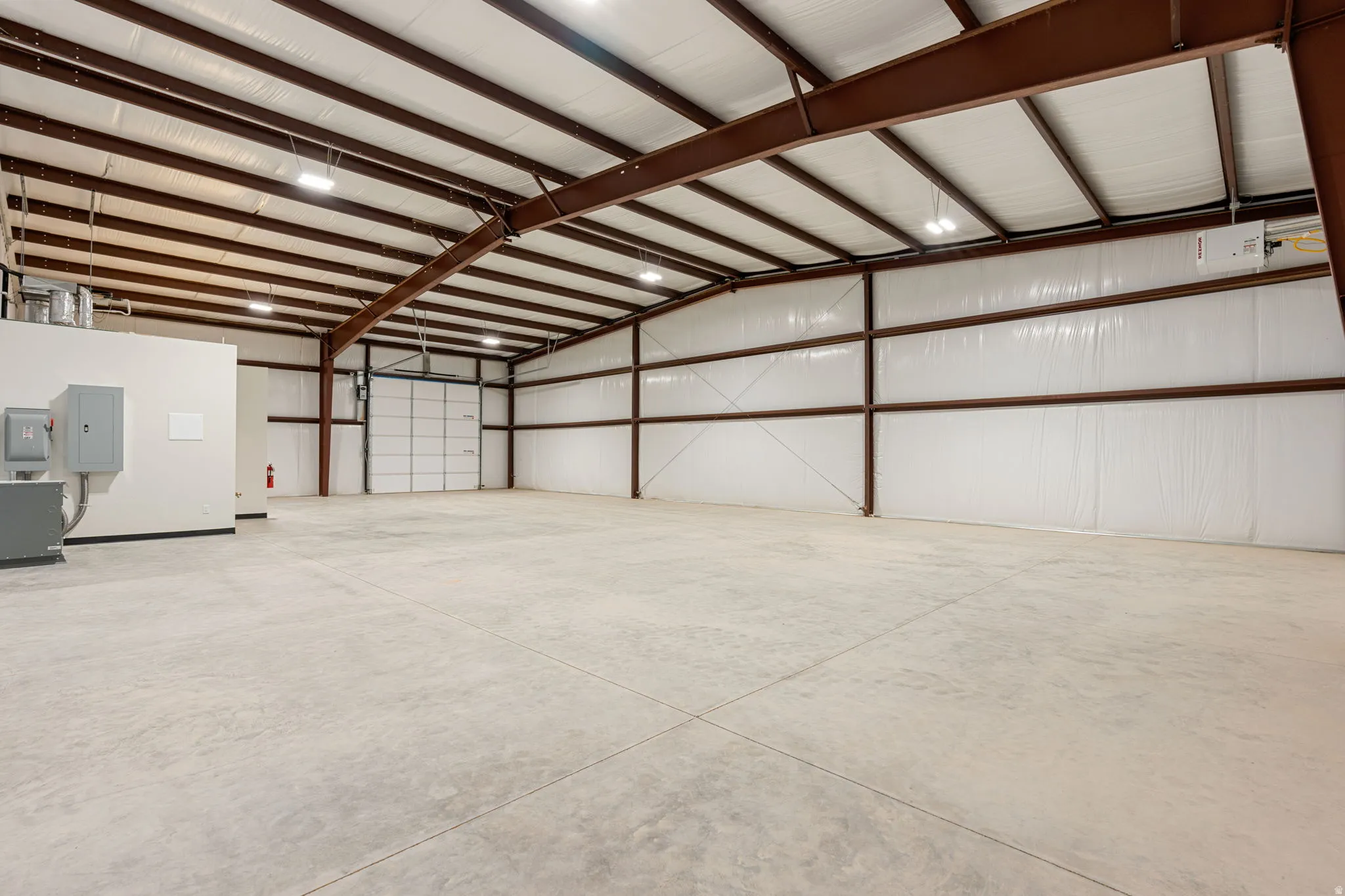 Garage featuring electric panel and metal wall
