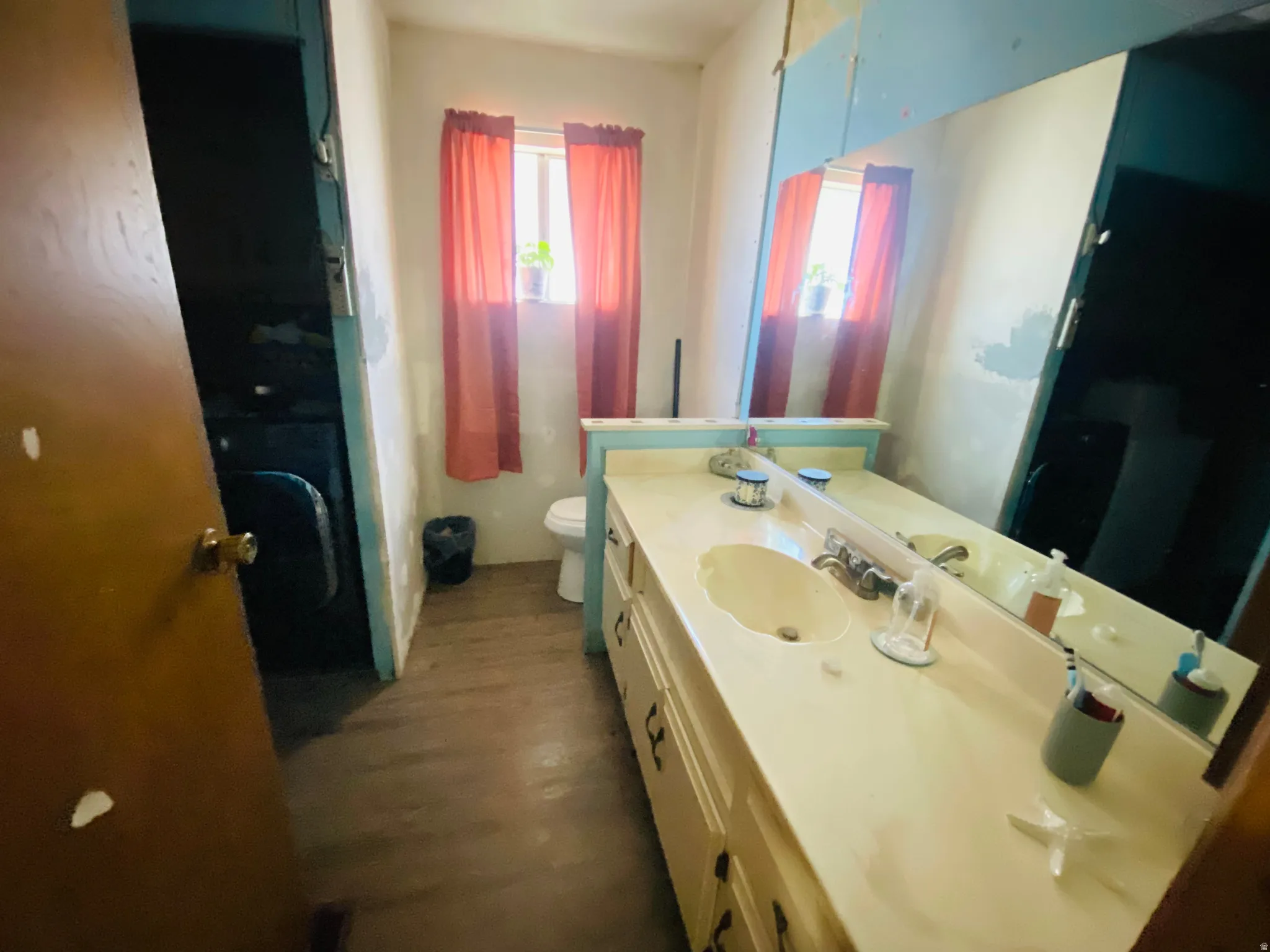 Full bath with vanity and dark wood-type flooring