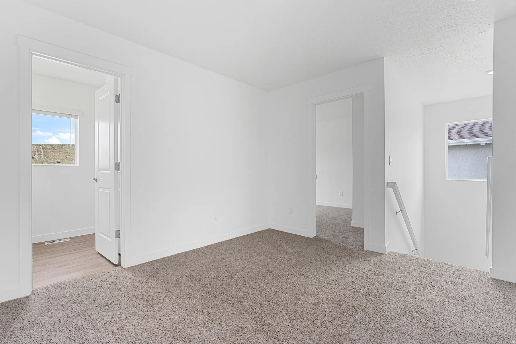 Empty room featuring light carpet and baseboards