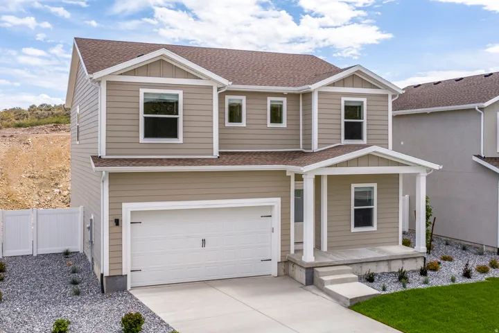 Two-story residence featuring tan siding and white trim