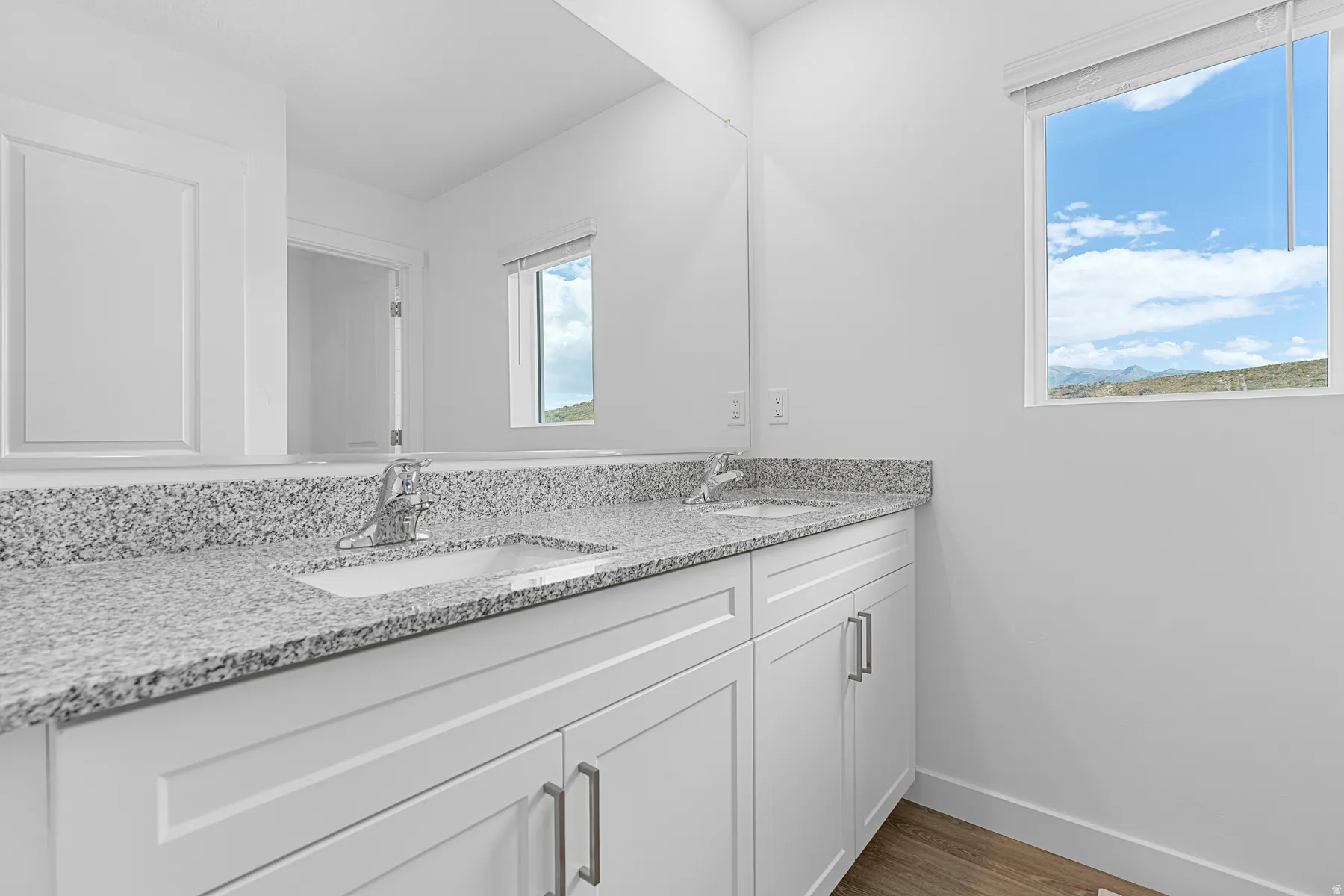 Bathroom with double vanity and dark wood finished floors