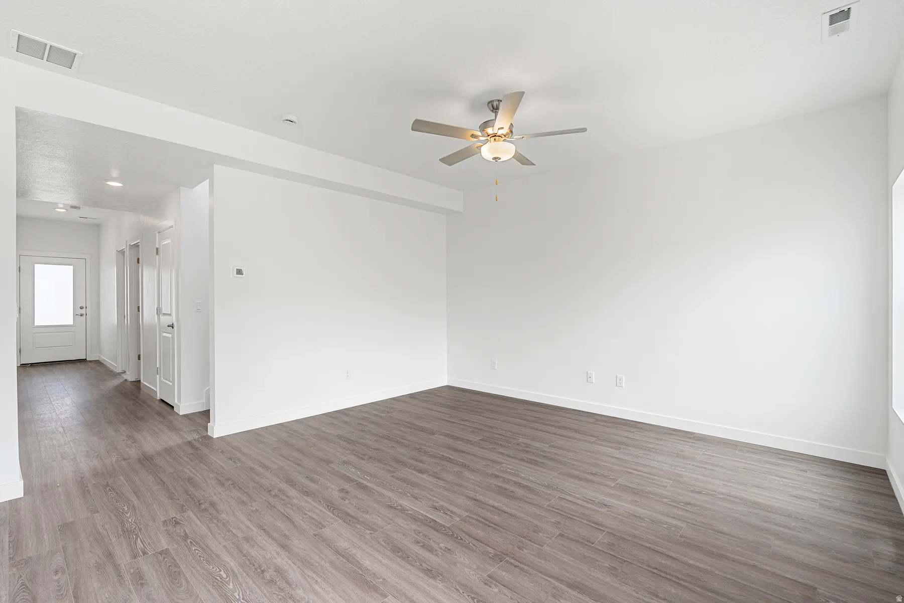Spare room with ceiling fan and dark wood-style flooring