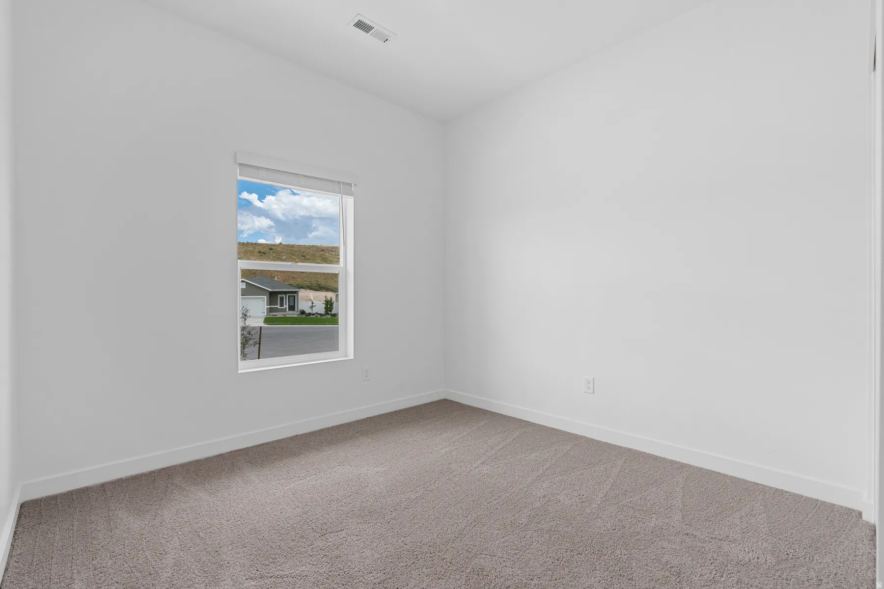 Carpeted empty room featuring baseboards