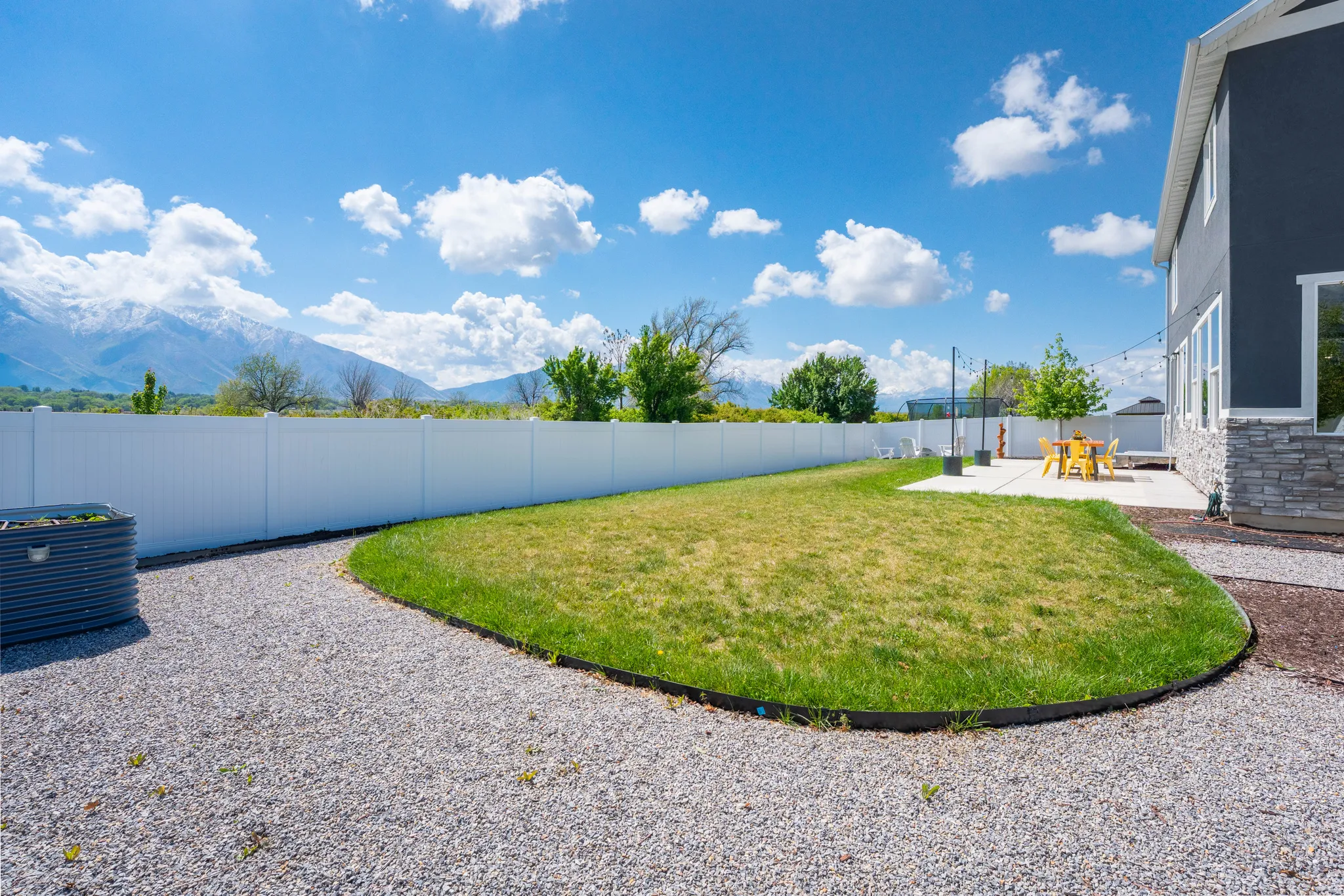 Fenced backyard featuring a mountain view and a patio area