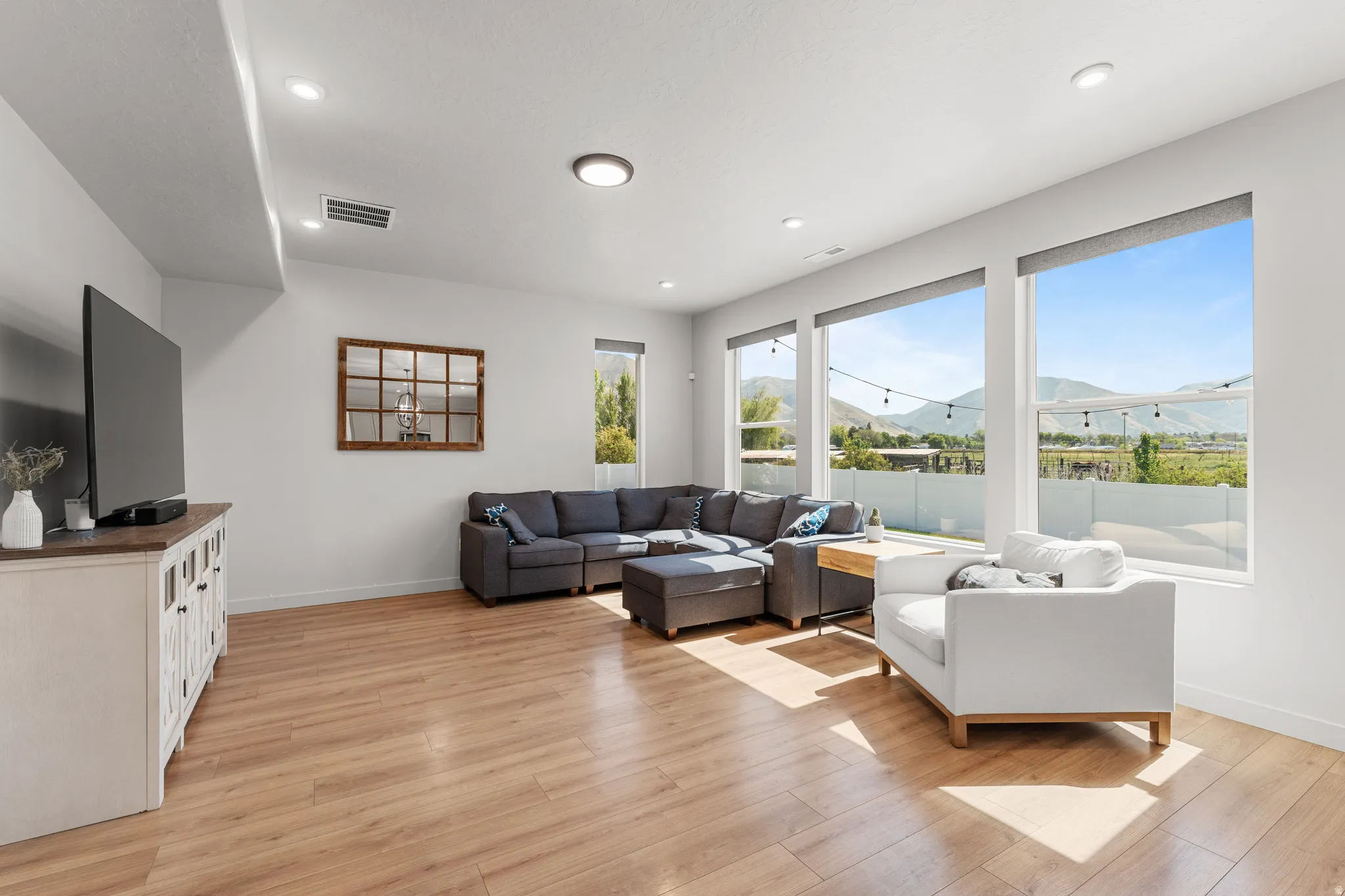 Living area with a mountain view, light wood-style floors, and recessed lighting