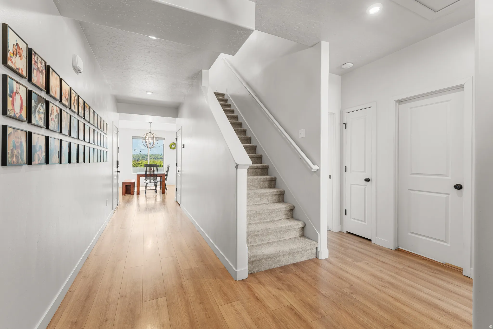Staircase with hardwood / wood-style floors and hanging lights