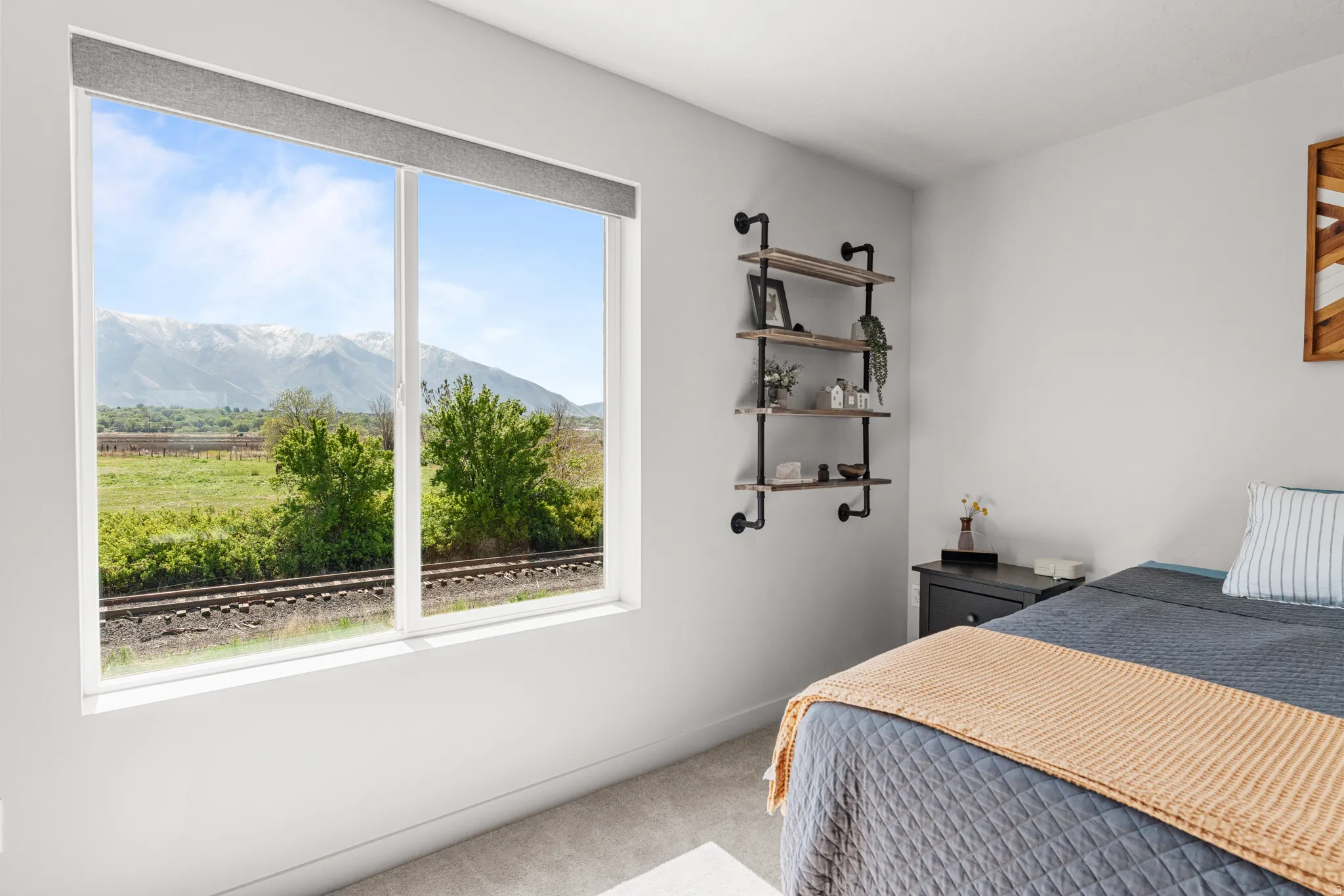 Bedroom with light colored carpet and a mountain view