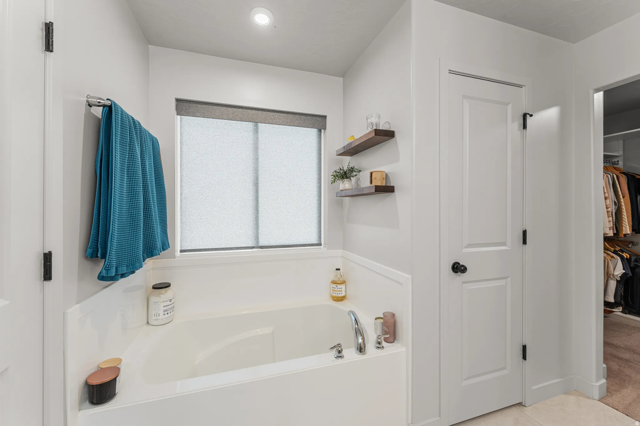 Bathroom featuring a garden tub and a spacious closet