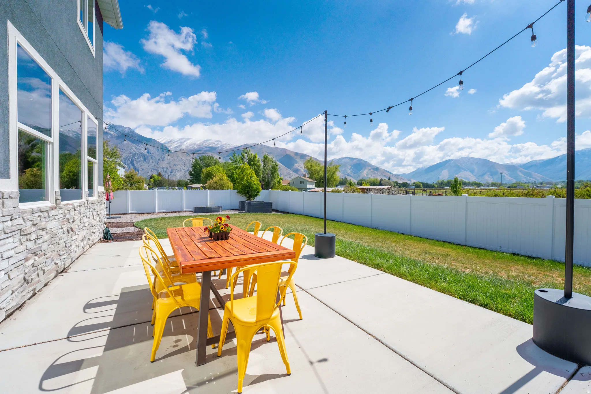 Fenced backyard with a mountain view, outdoor dining space, and a patio area