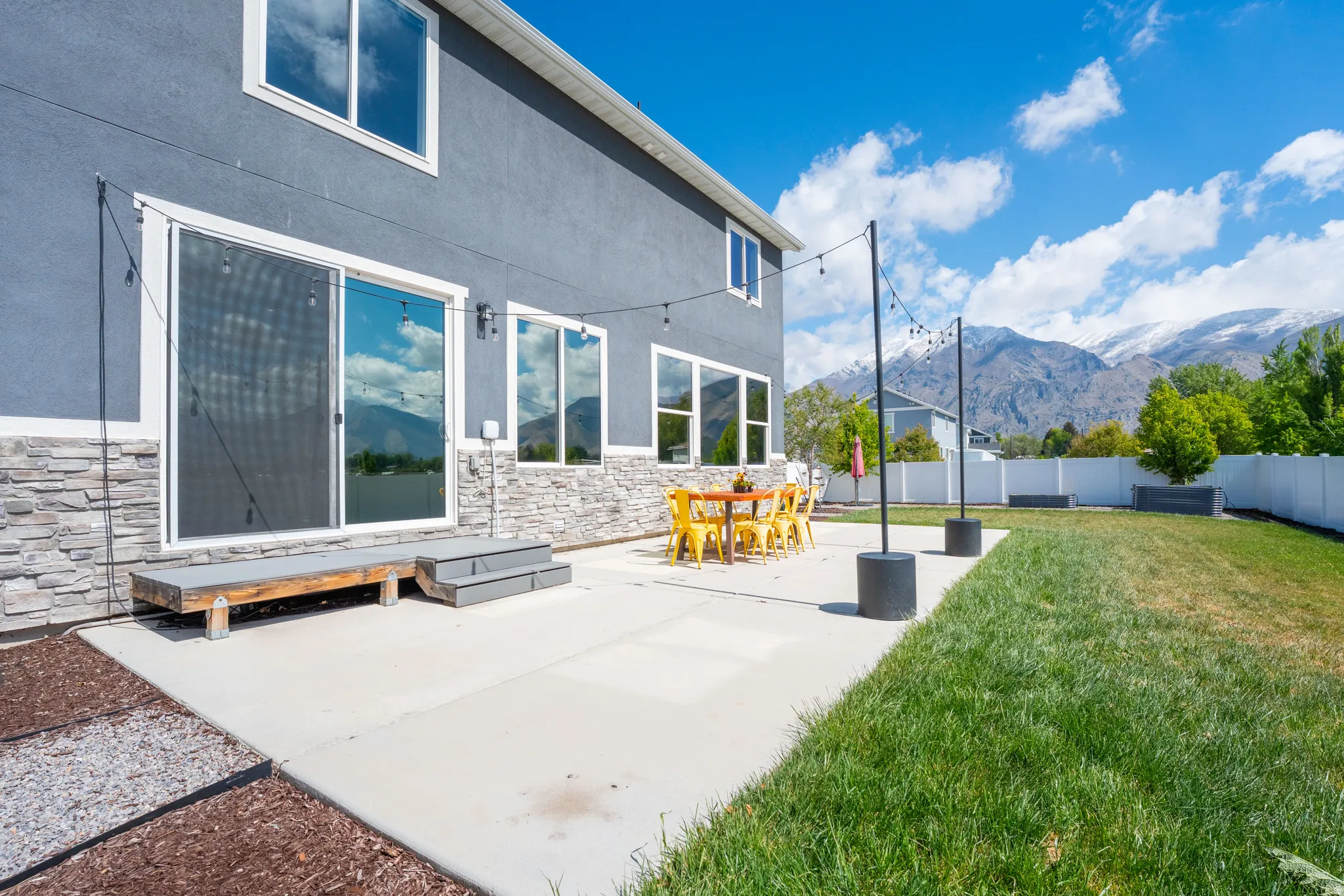 Fenced backyard featuring a mountain view, a patio, and outdoor dining area
