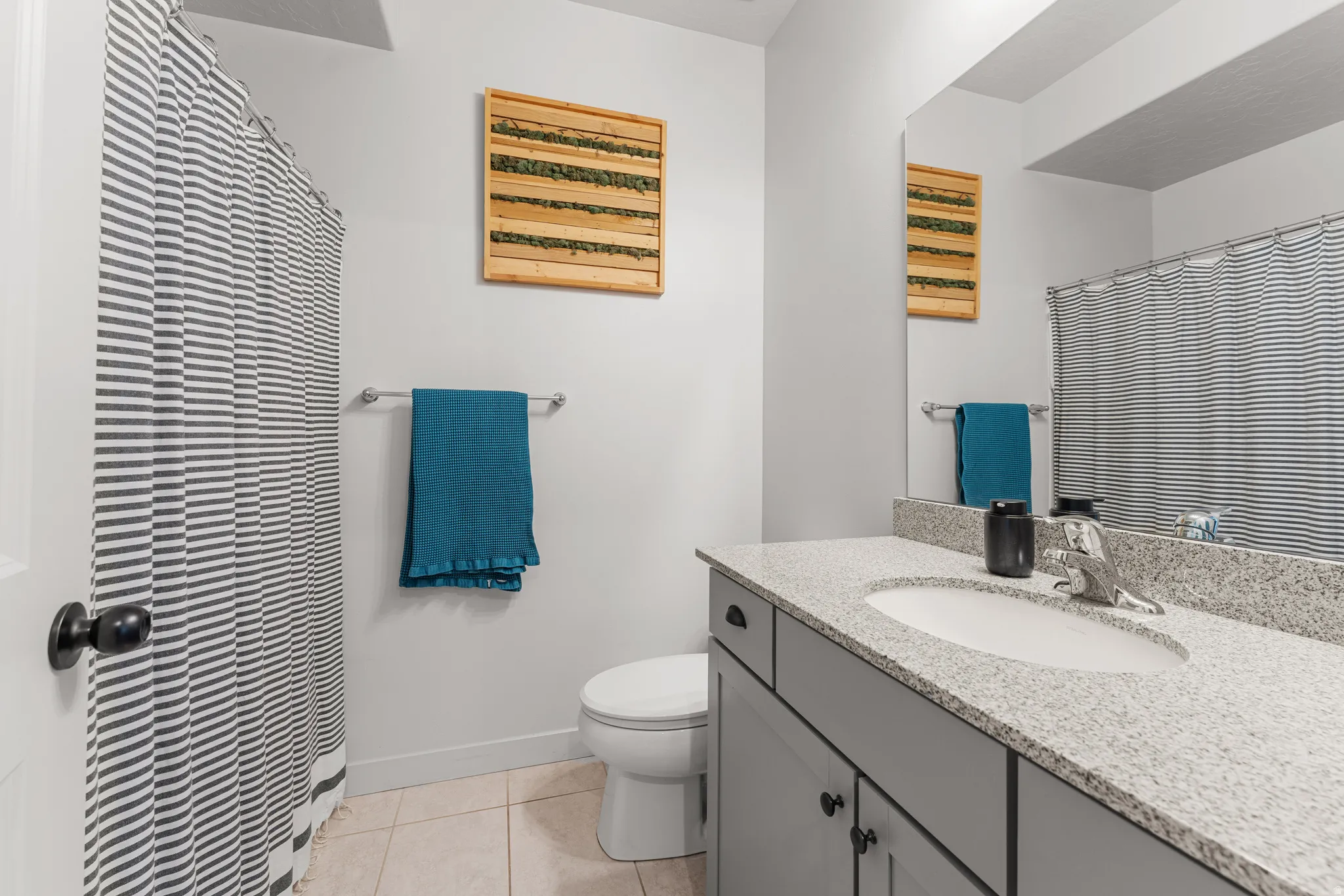 Bathroom featuring vanity, curtained shower, and light tile patterned floors