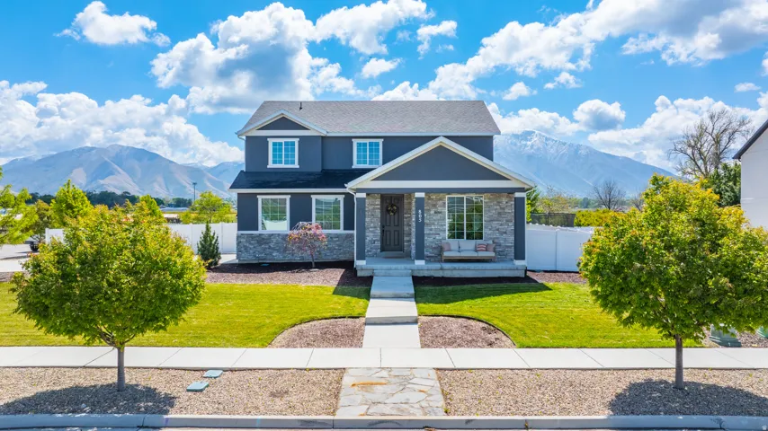 View of front of home featuring a mountain view, a porch, stone siding, and a shingled roof