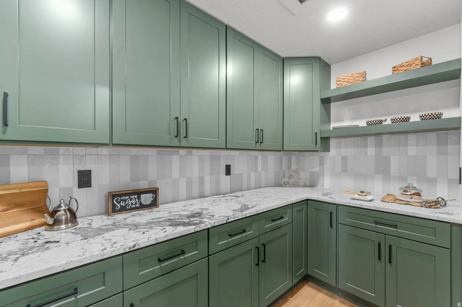 Kitchen with green cabinetry and open shelves