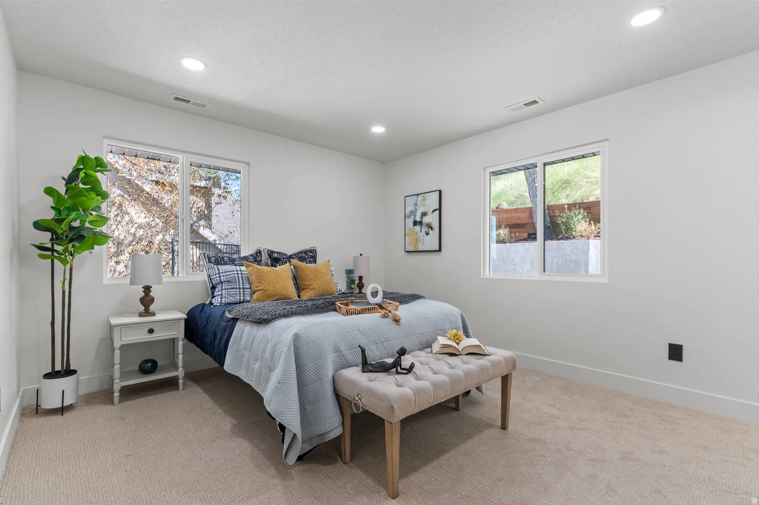 Bedroom featuring light carpet, multiple windows, and recessed lighting