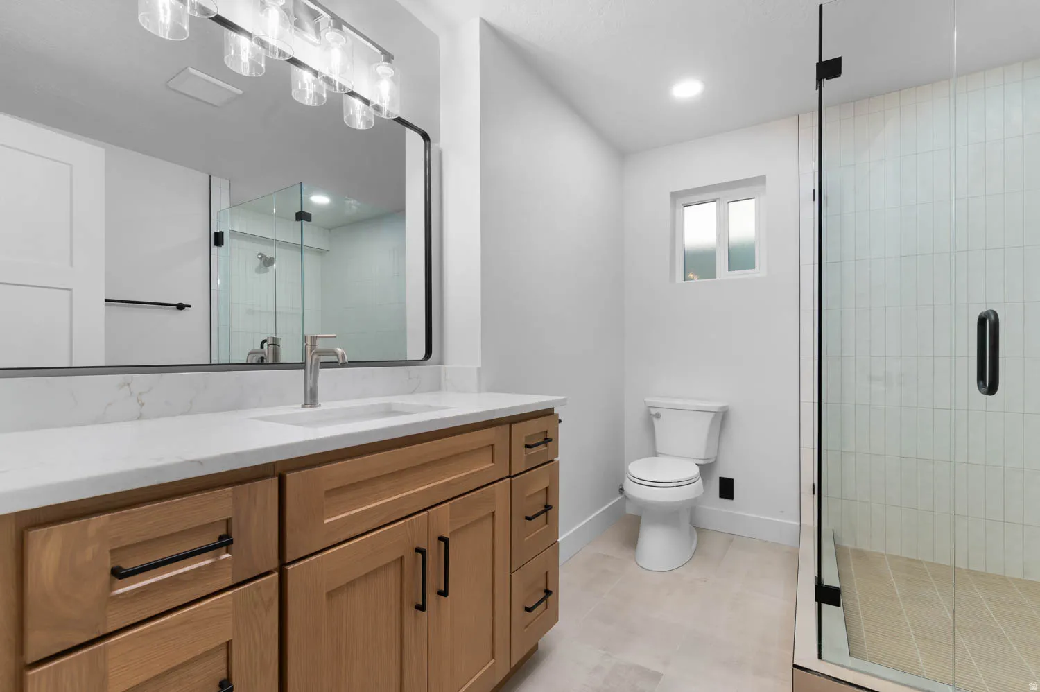 Contemporary bathroom featuring a light wood-finish vanity with a white countertop and rectangular undermount sink