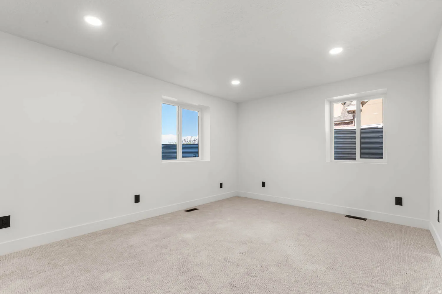 Spare room with healthy amount of natural light, light carpet, and recessed lighting