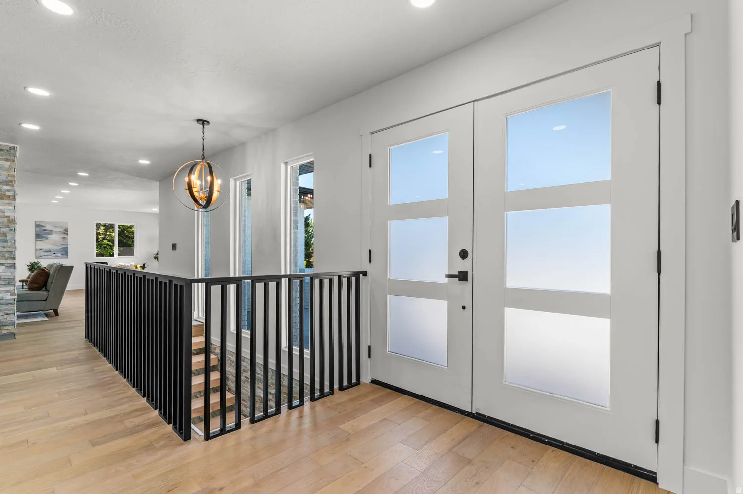 Foyer featuring light wood-style flooring, french doors, and hanging lights