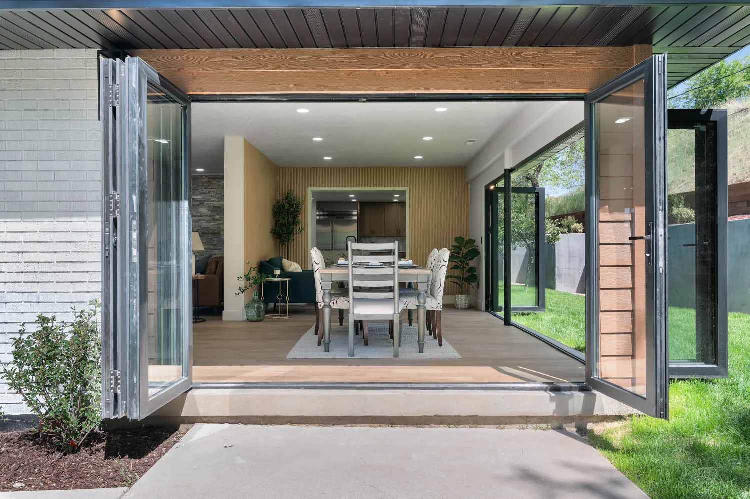 Bi-fold glass doors opening to a wood-finish flooring interior