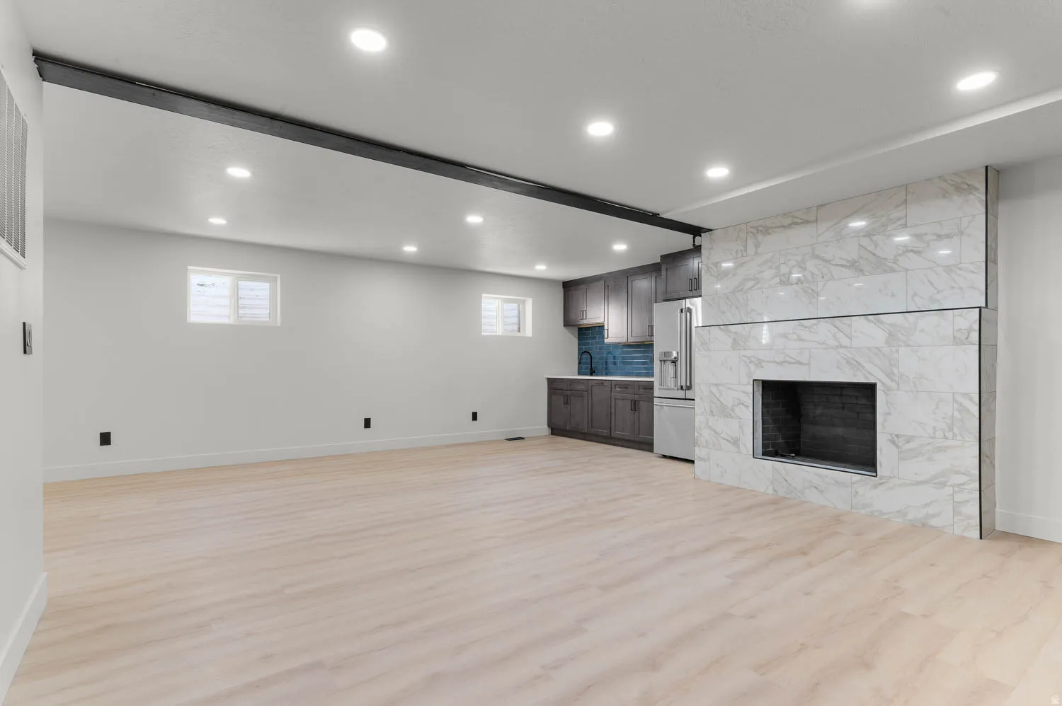 Unfurnished living room featuring light wood-type flooring, recessed lighting, and a premium fireplace
