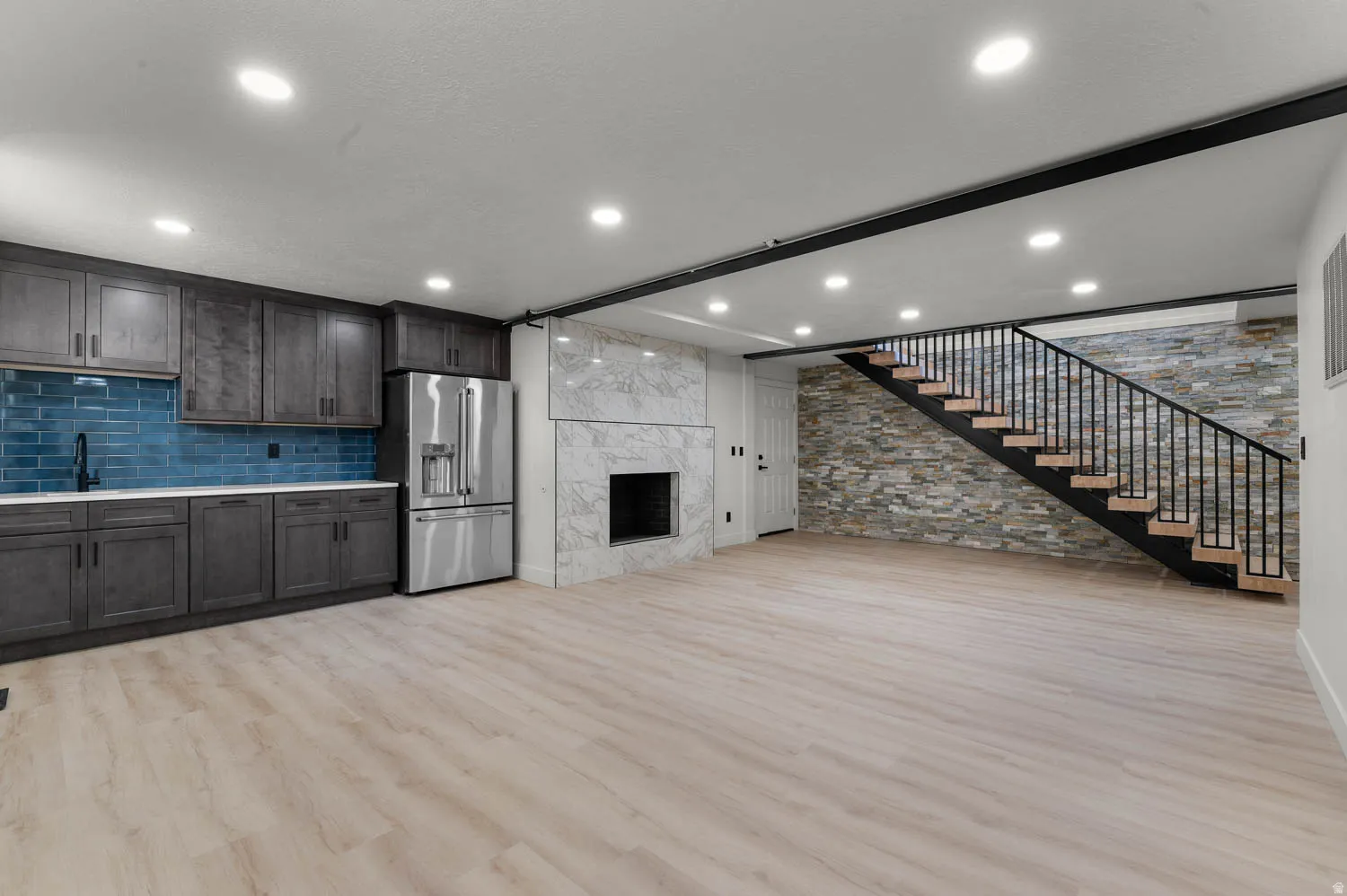 Unfurnished living room with light wood-style flooring, a high end fireplace, and recessed lighting