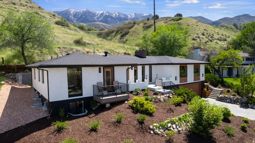 Contemporary exterior with white stucco and black accents, featuring a prominent wood-finish garage door