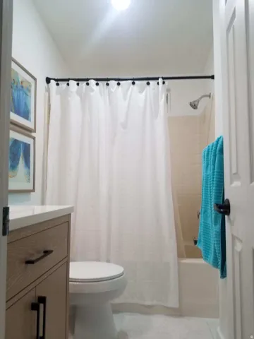 Bathroom featuring vanity and shower / bath combo with shower curtain
