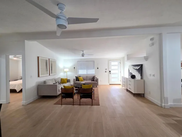 Living room featuring light wood-type flooring, ceiling fan, and a textured ceiling